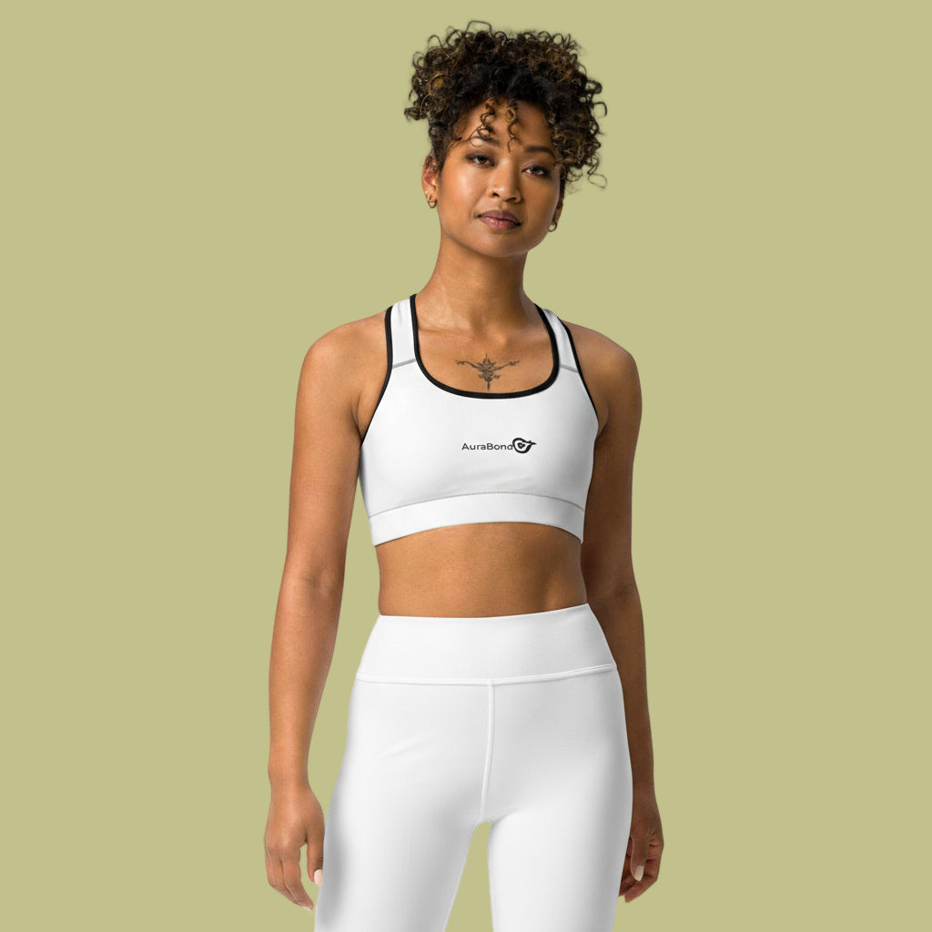 Woman wearing a white sports bra and leggings with a visible brand logo on a beige background