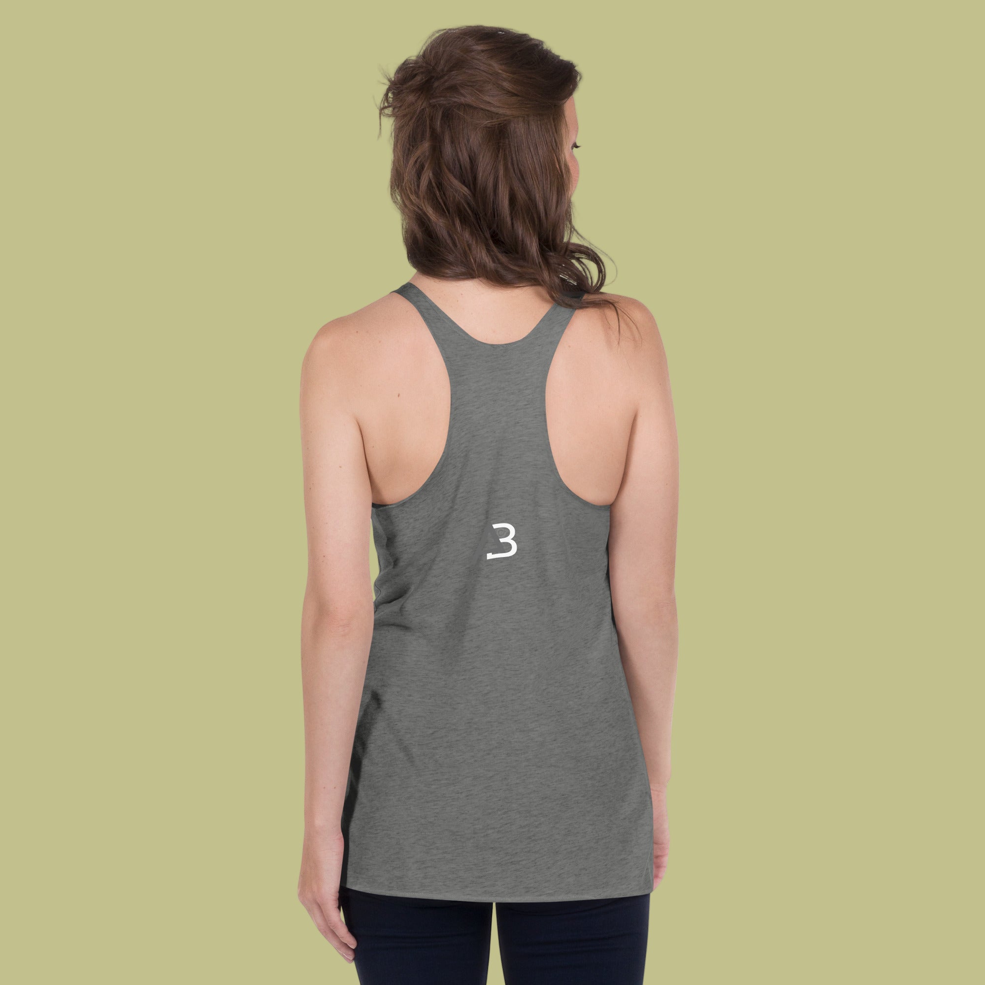 Person wearing a gray tank top with a white logo on the back against a green background