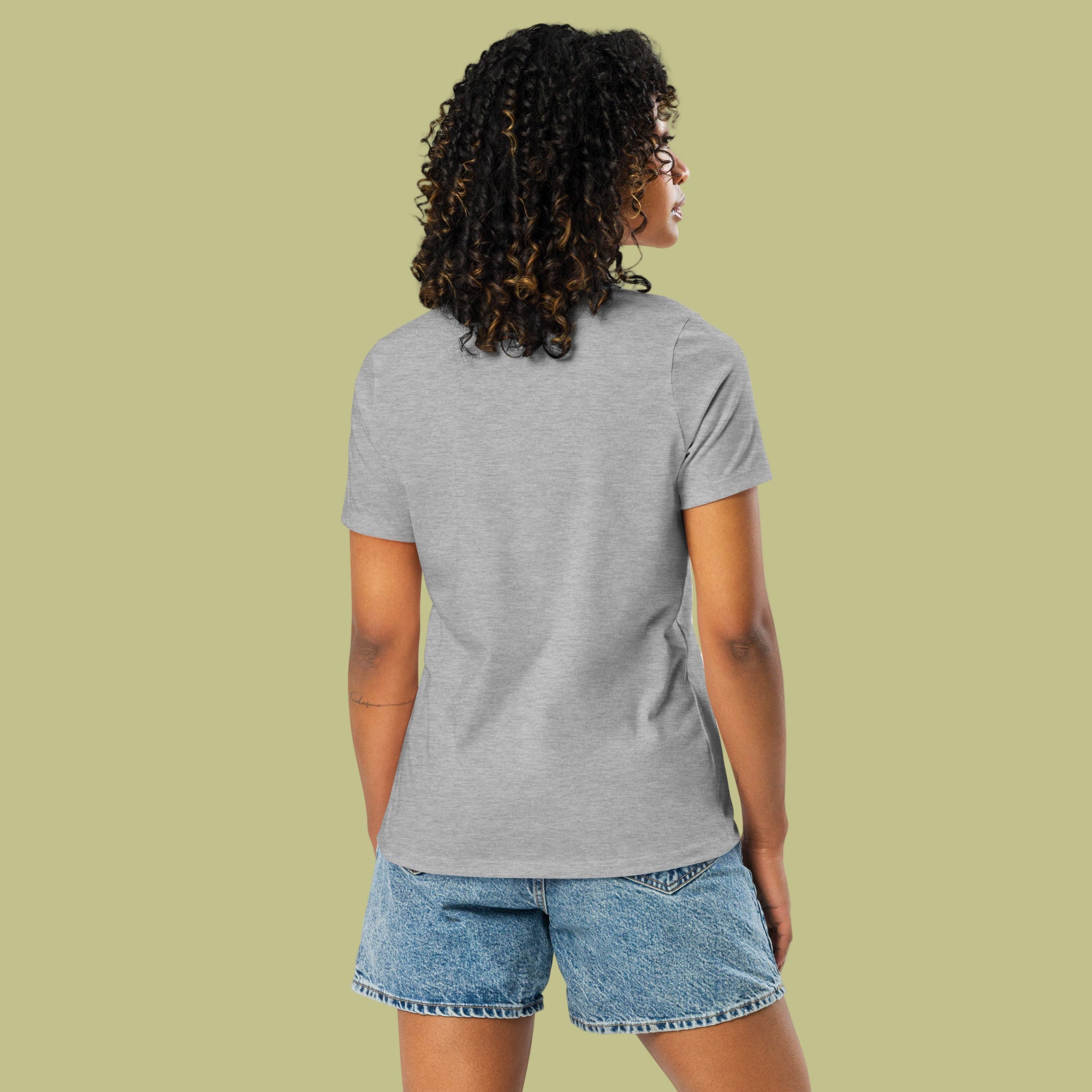 Person wearing a gray t-shirt and denim shorts on a light green background