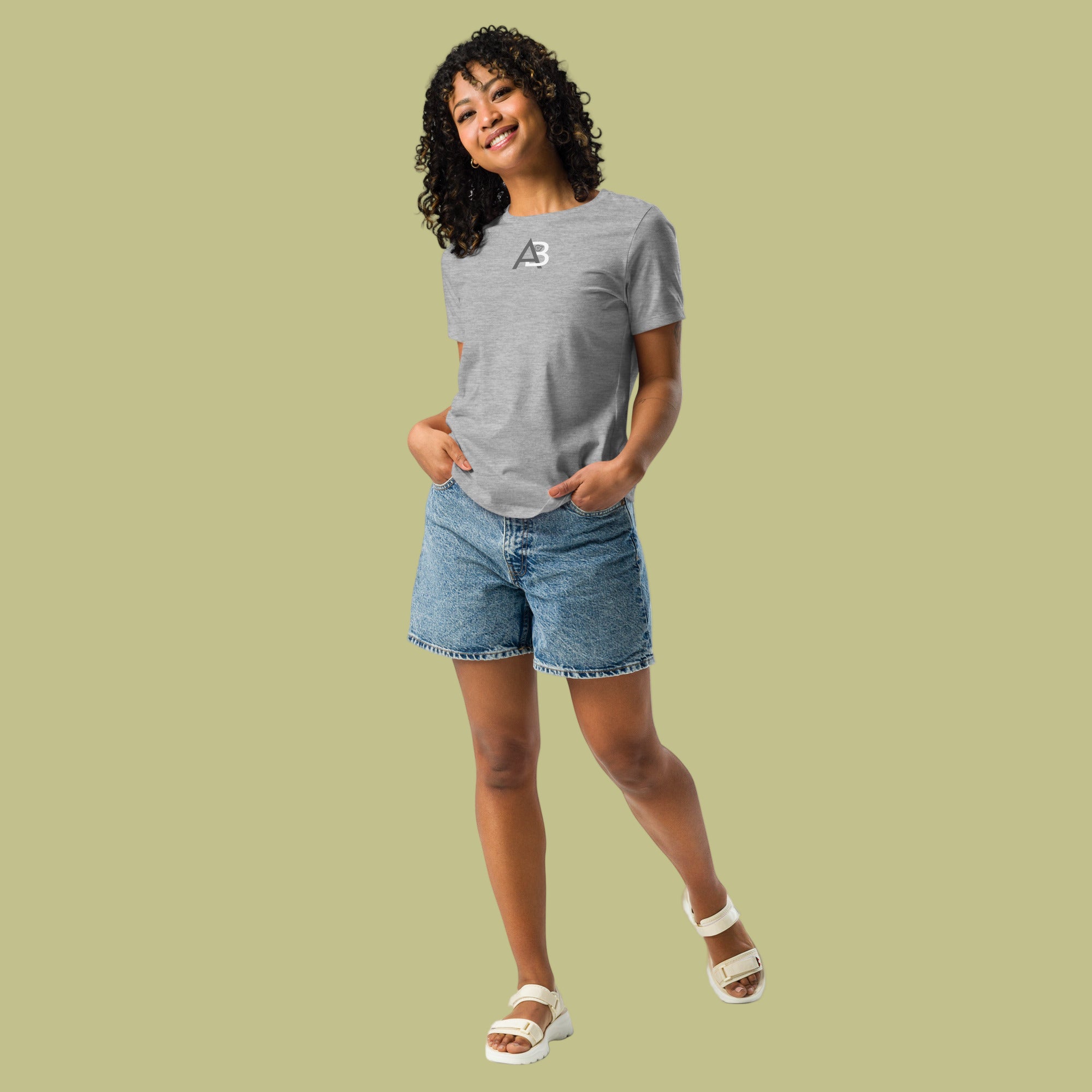 Person wearing a gray t-shirt and denim shorts on a green background