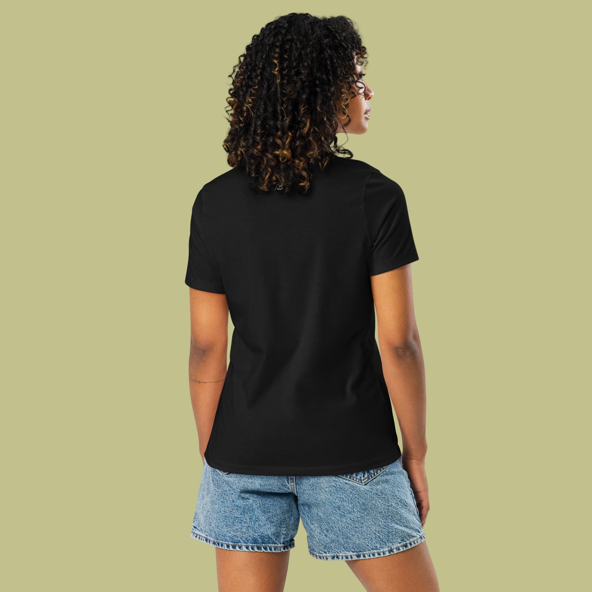 Person wearing a black t-shirt and denim shorts on a light green background