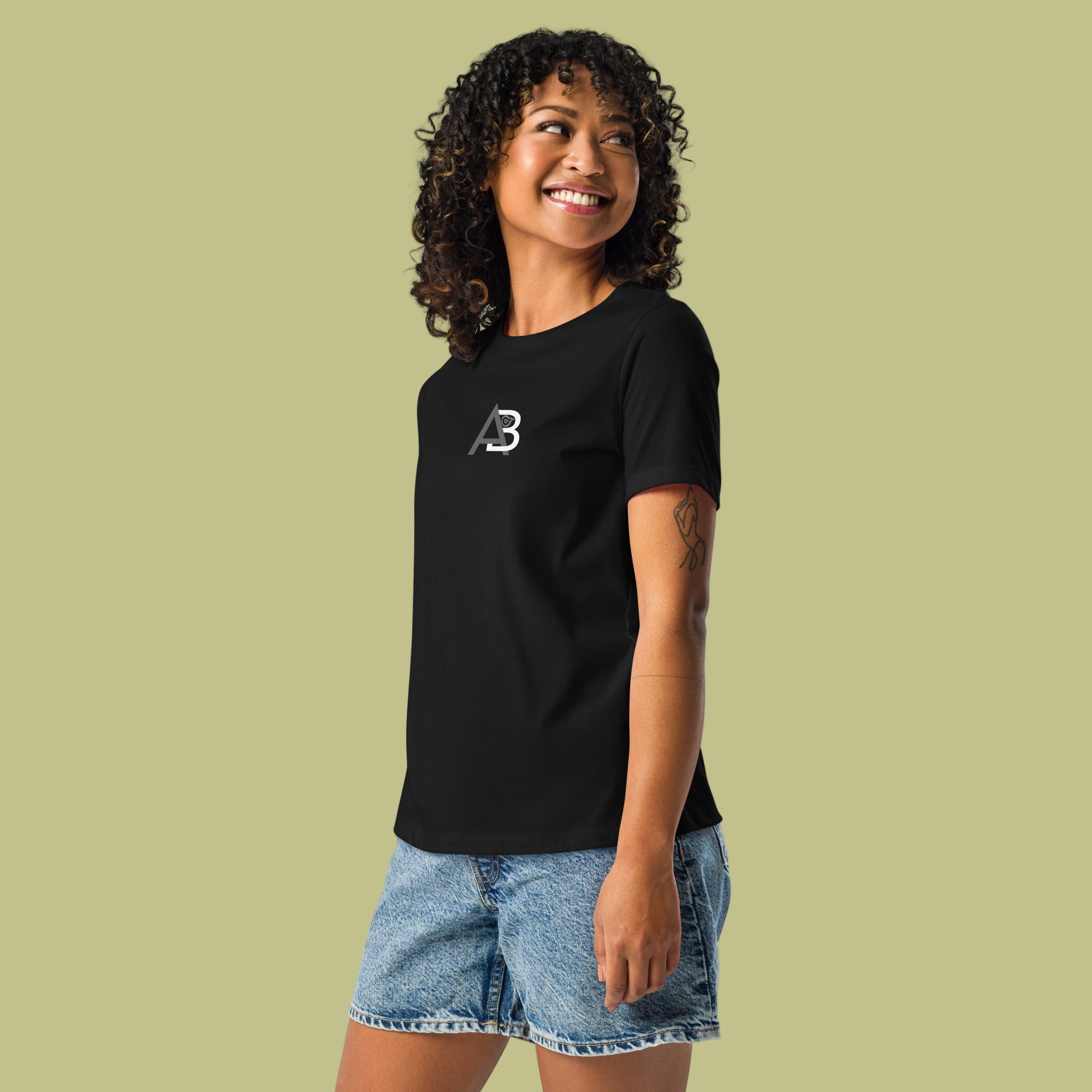 Woman wearing a black t-shirt with a logo on a light green background