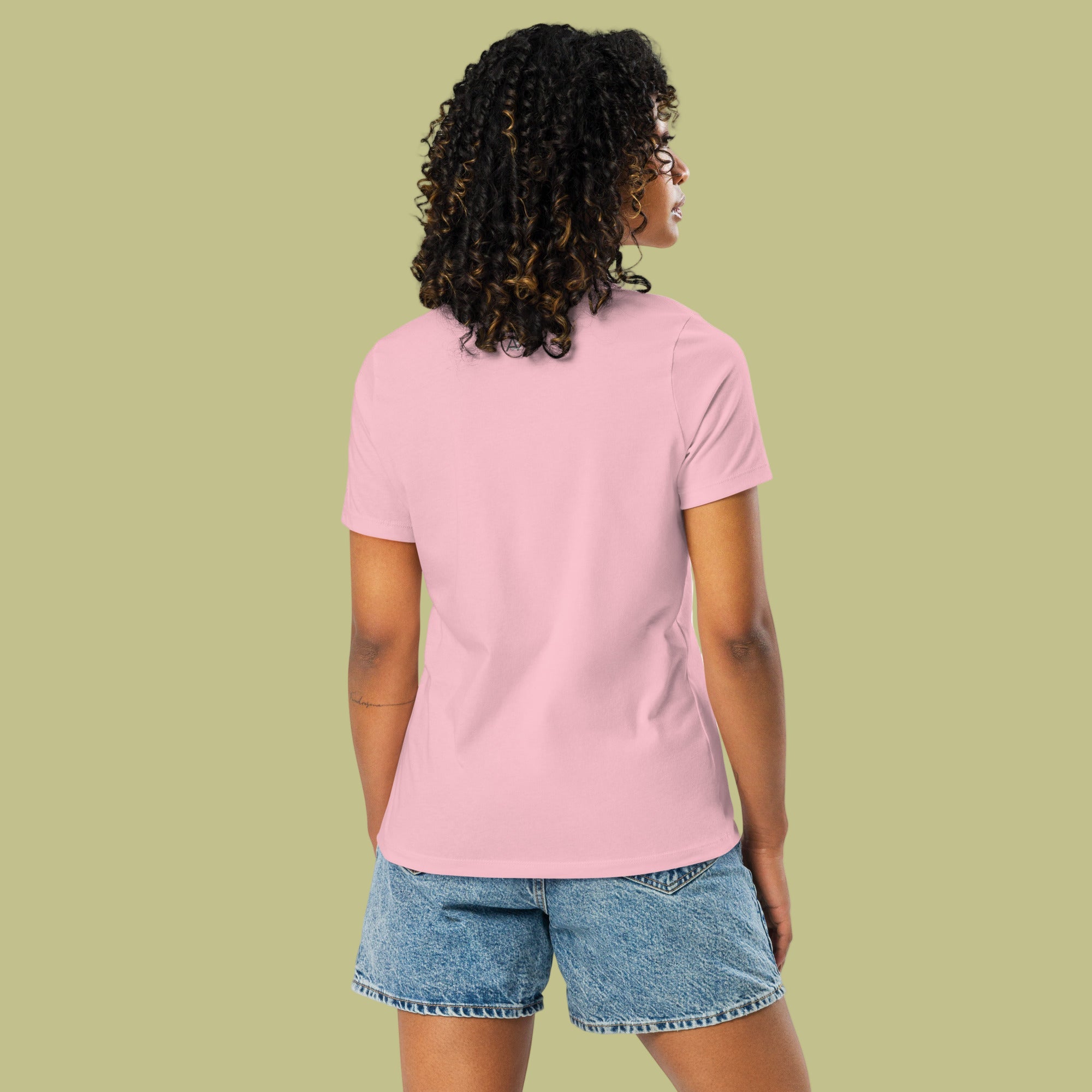 Person wearing a pink t-shirt and denim shorts on a solid background