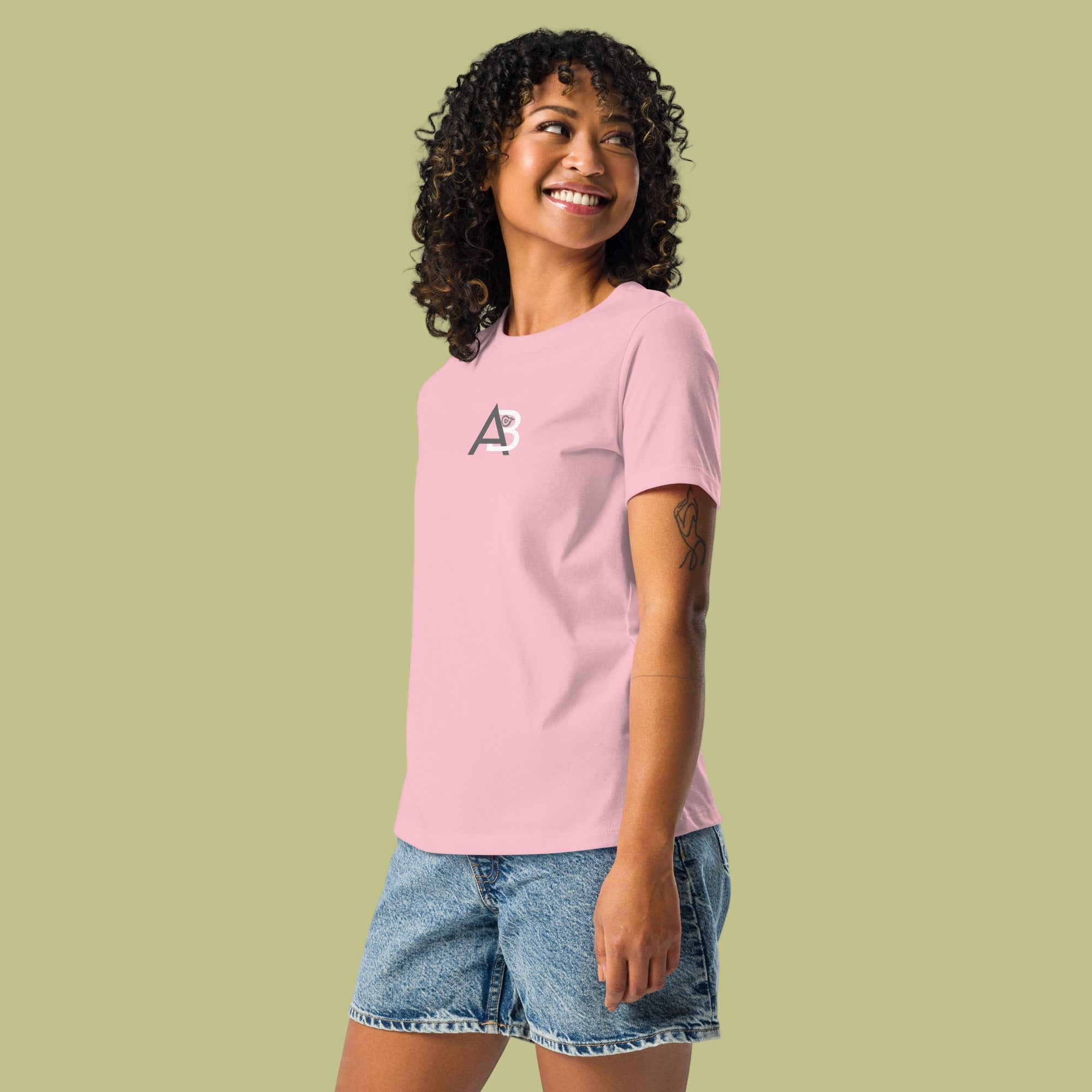 Woman wearing a pink t-shirt with a logo on a green background